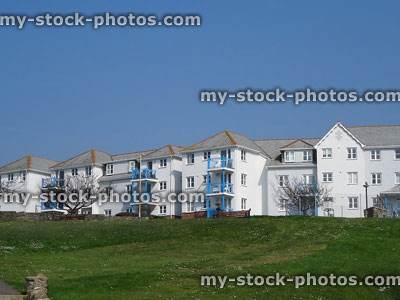 Stock image of white terraced houses with blue balconies overlooking hill