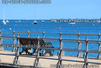 Stock image of English seaside, stone jetty / pier, Victorian railings, bench