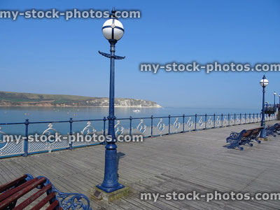 Stock image of pier with ornamental street lamps, railings, wrought iron benches