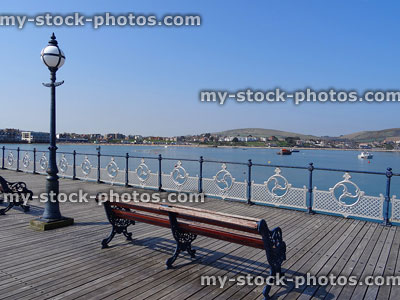 Stock image of Swanage town beach and pier with wrought iron benches