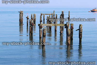 Stock image of old Swanage pier with rotten wooden posts / lifeboat