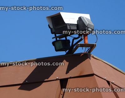 Stock image of CCTV surveillance / security camera on rooftop against sky