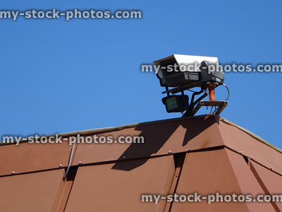 Stock image of rooftop surveillance CCTV security camera pointed down