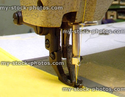 Stock image of sewing machine needle stitching yellow fabric / leather material