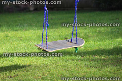 Stock image of garden swing made from recycled skateboard, in tree