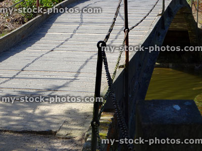 Stock image of wooden bridge over river, chain handrails, anti slip decking timber