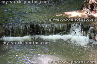 Stock image of gentle waterfall in landscaped rockery garden, water feature