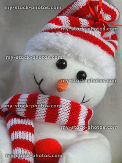 Stock image of cuddly toy cartoon Snowman, red and white hat and scarf