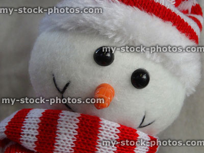 Stock image of cuddly toy cartoon Snowman, red and white hat and scarf