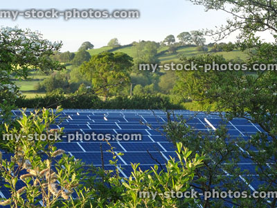Stock image of countryside farm field with solar panels, photovoltaic power