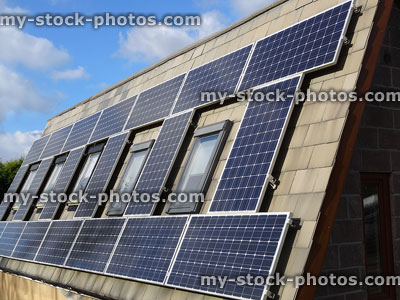 Stock image of steep roof with solar panels around windows, solar power / energy