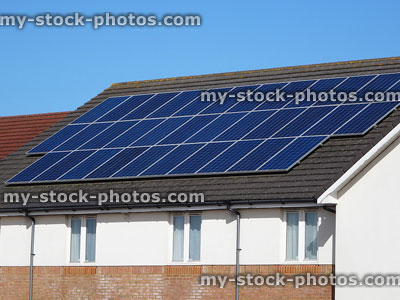 Stock image of building with rows of solar panels on roof