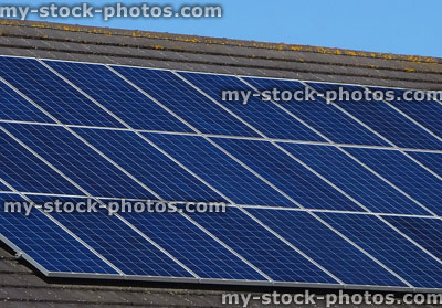 Stock image of solar panels in rows on roof tiles, solar power energy