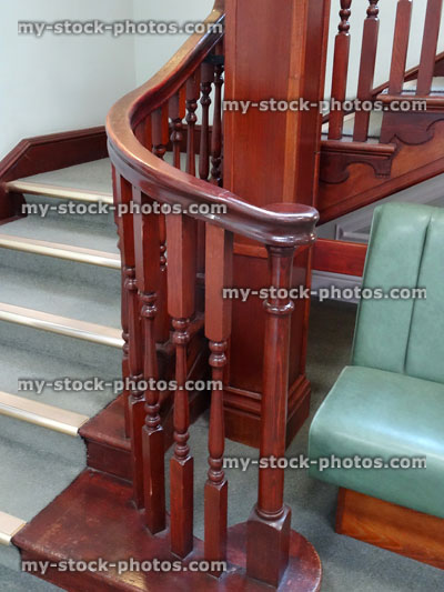 Stock image of wooden stair bannisters / spindles, staircase, green carpet, metal edging
