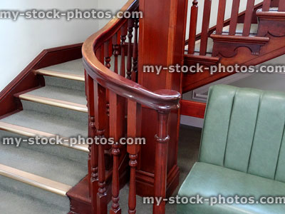 Stock image of wooden stair bannisters / spindles, staircase, green carpet, metal nosing