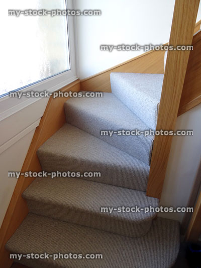 Stock image of stairs in house, staircase corner, cream carpet, wooden spindles