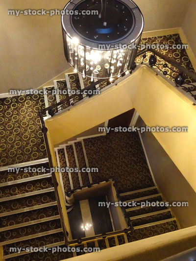 Stock image of stairs / staircase, black art deco metal bannister, wrought iron staircase balustrading ironwork, chandelier