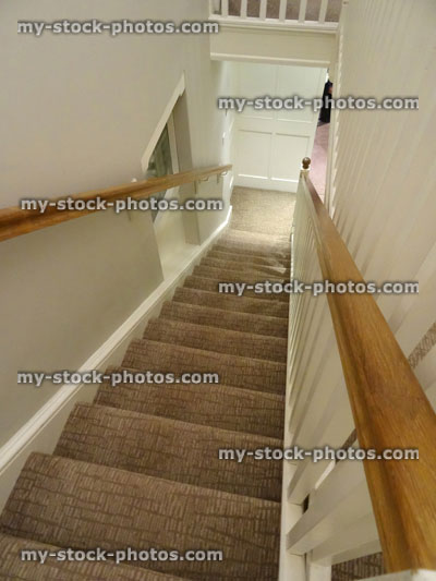 Stock image of long staircase / stairs, patterned brown carpet, wooden handrail