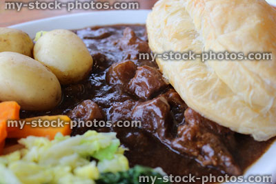 Stock image of steak pie, new potatoes, carrots, cabbage, gravy, puff pastry