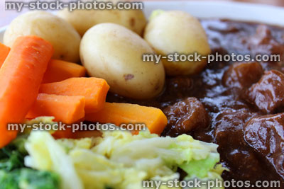 Stock image of steak and kidney pie, new potatoes, carrots, cabbage, gravy, puff pastry