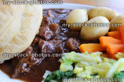 Stock image of steak pie, new potatoes, carrots, cabbage, gravy, puff pastry