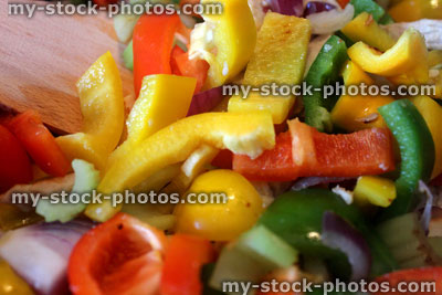 Stock image of stir fry being cooked, peppers, onions, chicken, celery, wooden spatula