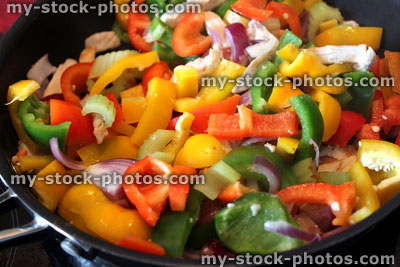 Stock image of stir fry being cooked, peppers, onions, chicken, celery, frying pan