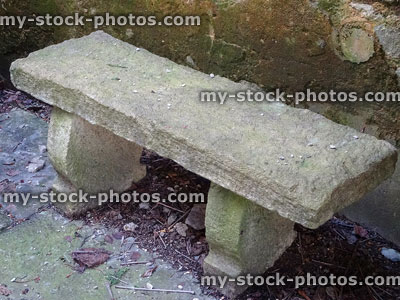 Stock image of small stone bench seat in garden, formal seating