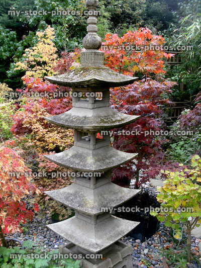 Stock image of tall Japanese stone pagoda, oriental garden with maples