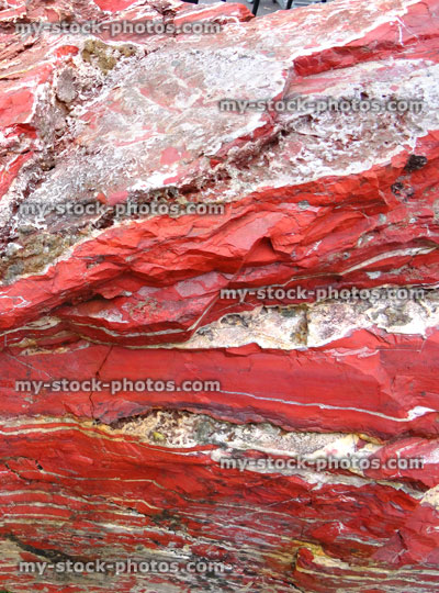 Stock image of large red marble rock, quartz veins, metamorphic rock surface