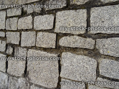 Stock image of irregular granite blocks making up seaside stone wall