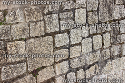 Stock image of granite stone wall with irregular shape bricks / blocks