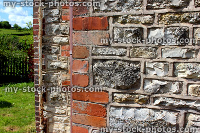 Stock image of repointed mortar in red brick, stone and flint cottage wall