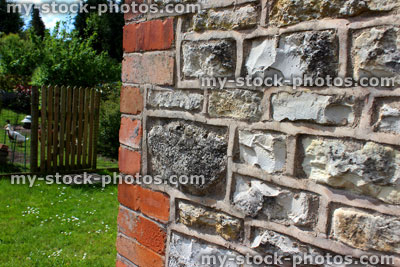 Stock image of freshly repointed brick, stone, flint wall on cottage