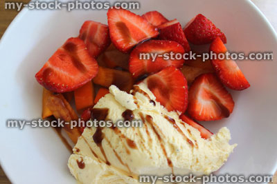 Stock image of cut strawberries with ice cream and balsamic vinegar