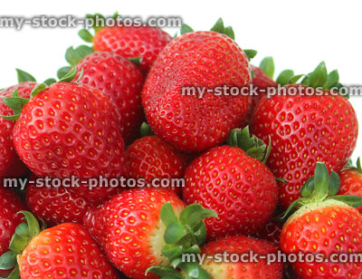 Stock image of fresh red strawberries, strawberry fruit / green stalks, white dish