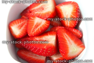 Stock image of sliced strawberries in half, white dish, healthy eating, fresh fruit