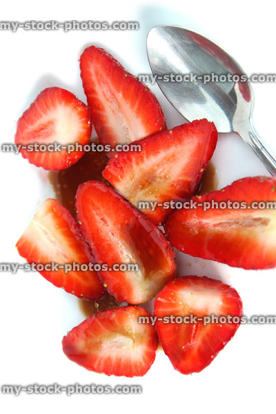 Stock image of sliced strawberries with balsamic vinegar, sugar, healthy dessert, white background