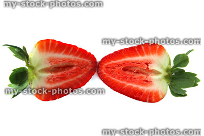 Stock image of two ripe strawberry slices, sliced in half, white background