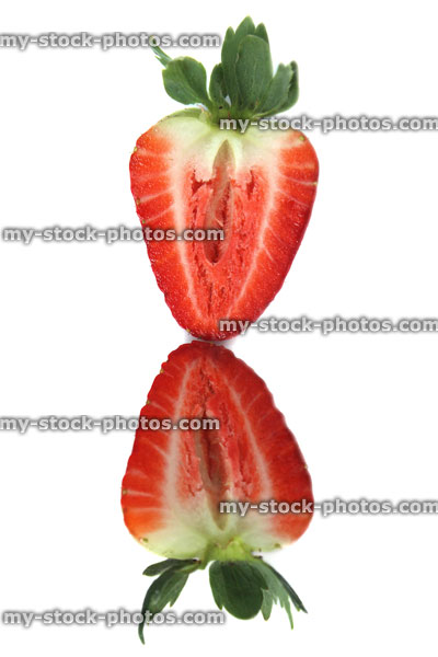 Stock image of strawberry cut in half, summer fruit reflecting in mirror
