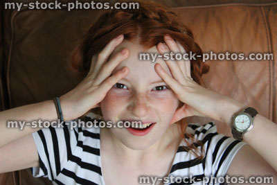 Stock image of stressed girl with head in hands, tense, anxiety