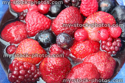 Stock image of defrosted summer fruit berries, strawberries, raspberries, blueberries, juices