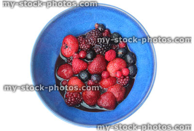 Stock image of blue dish of red / black summer fruit berries / juices