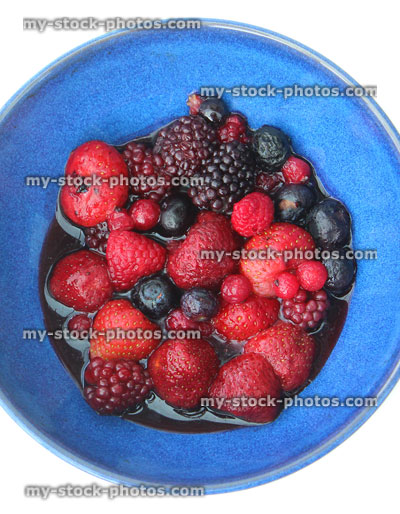 Stock image of blue dish with defrosted summer fruit berries in juice