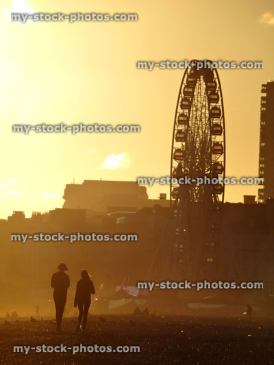 Stock image of boy and girl on sunset beach with big wheel