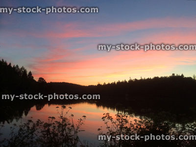 Stock image of lake with orange evening sunset reflections on water