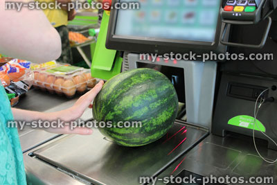 Stock image of girl scanning shopping (watermelon) at self service supermarket checkout till (self checkout)