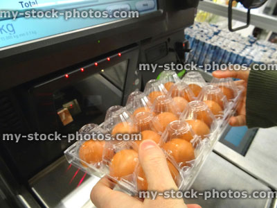 Stock image of girl scanning shopping (eggs) at self service supermarket checkout till (self checkout)
