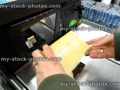 Stock image of girl scanning shopping (cheese) at self service supermarket checkout till (self checkout)