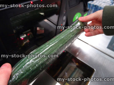 Stock image of girl scanning shopping (cucumber) at self service supermarket checkout till (self checkout)